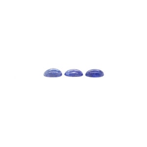 May include: Three blue oval cabochon gemstones, each with a slightly different shade of blue.