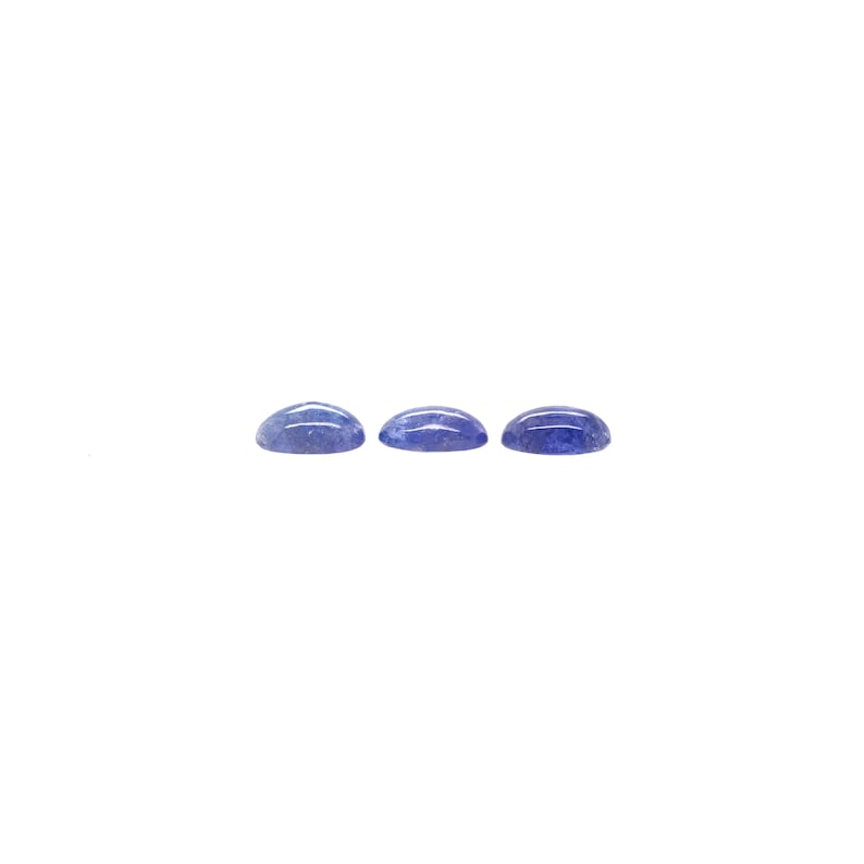 May include: Three blue oval cabochon gemstones, each with a slightly different shade of blue.