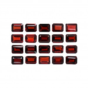 May include: A collection of 18 rectangular red gemstones, arranged in three rows of six. The gemstones are all the same size and shape, and they are set against a white background.