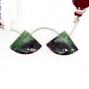 May include: Two green and purple gemstone beads with a faceted, half-moon shape. The beads are strung on a silver wire.