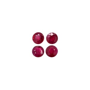 May include: Four round, red ruby gemstones. The gemstones are faceted and have a polished finish.