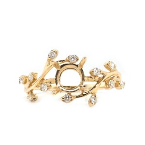 Puede incluir: Un anillo de oro con un delicado dise&ntilde;o de ramas engastado con peque&ntilde;os diamantes. El anillo tiene un engaste central para una piedra m&aacute;s grande.