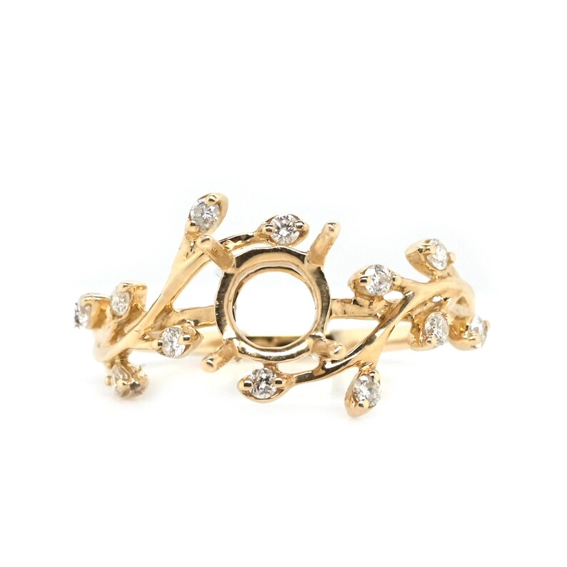 Puede incluir: Un anillo de oro con un delicado dise&ntilde;o de ramas engastado con peque&ntilde;os diamantes. El anillo tiene un engaste central para una piedra m&aacute;s grande.