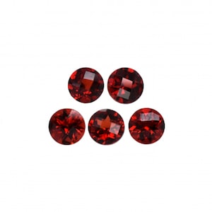Może przedstawiać: Pięć okrągłych, czerwonych kamieni szlachetnych o szlifie fasetowym. Kamienie szlachetne są ułożone w półkole.