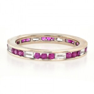 May include: A gold band ring with a row of small red rubies and a row of baguette-cut diamonds.