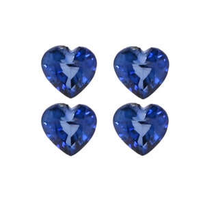 May include: Four heart-shaped blue sapphire gemstones. The sapphires are faceted and have a deep blue color.