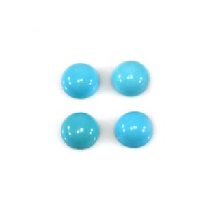 Może przedstawiać: Cztery okrągłe kaboszony turkusowe, każdy z gładką, wypolerowaną powierzchnią. Kaboszony są ułożone w siatkę dwa na dwa na białym tle.