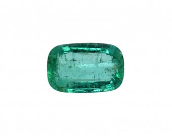 Puede incluir: Una esmeralda tallada en forma rectangular, de color verde vibrante. La gema translúcida tiene bordes redondeados e inclusiones internas visibles. La superficie refleja la luz, resaltando sus facetas. La esmeralda se encuentra sobre un fondo blanco liso.