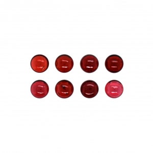 May include: Eight round, red gemstones, some darker than others, arranged in two rows of four.