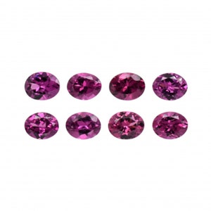 Peut inclure: Huit pierres précieuses de forme ovale, toutes d'une couleur rose-violet vibrante. Les pierres précieuses sont disposées en deux rangées de quatre, chaque pierre précieuse étant séparée des autres.