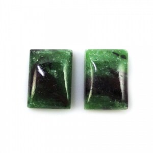 May include: Two green and black rectangular gemstones with a smooth, polished finish.