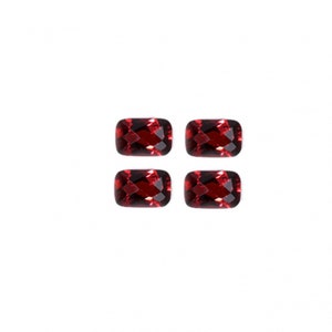 May include: Four red rectangular gemstones with faceted edges.