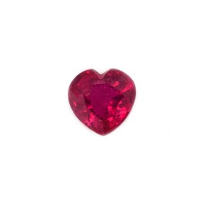 May include: A heart-shaped, faceted ruby gemstone. The ruby is a deep, vibrant red color, with a polished surface that reflects light. The gemstone is set against a white background.