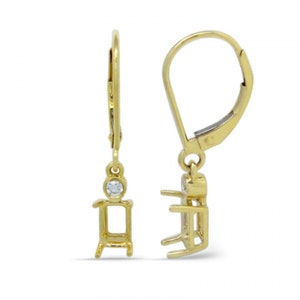 Op de afbeelding: Een paar gouden oorhangers met een klein diamant accent. De oorbellen hebben een rechthoekige zetting voor een grotere steen.
