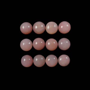 K&ouml;nnte beinhalten: Zw&ouml;lf runde, blassrosa Opal-Cabochons, angeordnet in drei Reihen zu vier. Die Cabochons sind glatt und poliert.