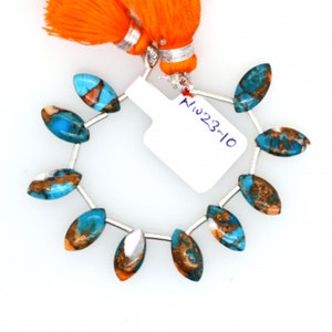 May include: A strand of 10 turquoise and copper marquise shaped beads with silver spacers. The beads are approximately 1 inch long. The beads are strung on a silver wire and have a white tag with the number "NW223-10" written on it.