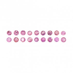 May include: A collection of 18 round pink gemstones, arranged in two rows of nine. The gemstones are all the same size and shape, and they are set in a clear, transparent material.
