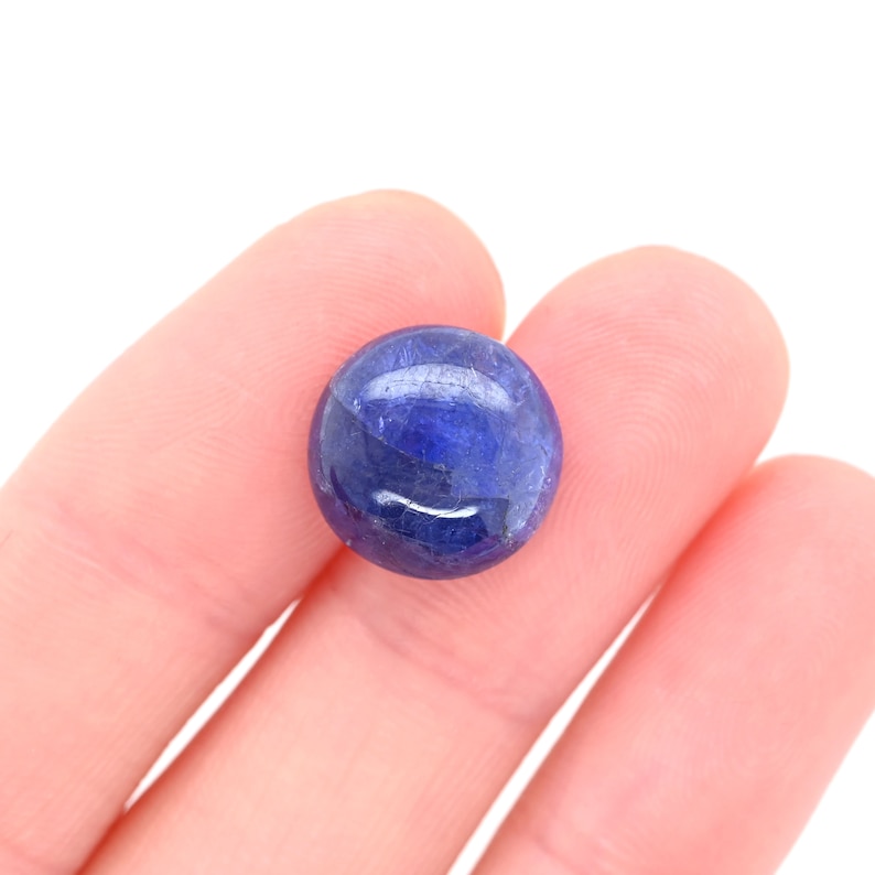 May include: A round, blue gemstone with a smooth, polished surface.