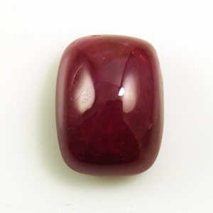 May include: A deep red, cabochon cut gemstone with a smooth, polished surface.