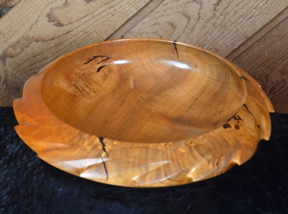 A hand-carved Chittim wood bowl that's more sculpture than vessel — the grain and form are one-of-a-kind by definition.