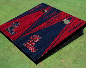 May include: A set of two red and blue wooden cornhole boards with the Ole Miss Rebels logo and the words "Ole Miss" and "Rebels" printed on them.