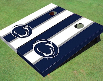 May include: A set of two blue and white striped cornhole boards with a white Nittany Lion logo on each board.