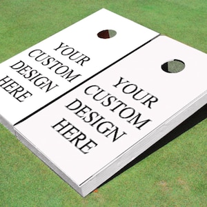 May include: White wooden cornhole game set with two boards. Each board has a hole in the center and the text "Your Custom Design Here" printed on the surface.