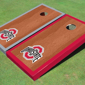 May include: A set of two wooden cornhole boards with a red and gray trim. The boards are decorated with the Ohio State University logo in red, gray, and black.