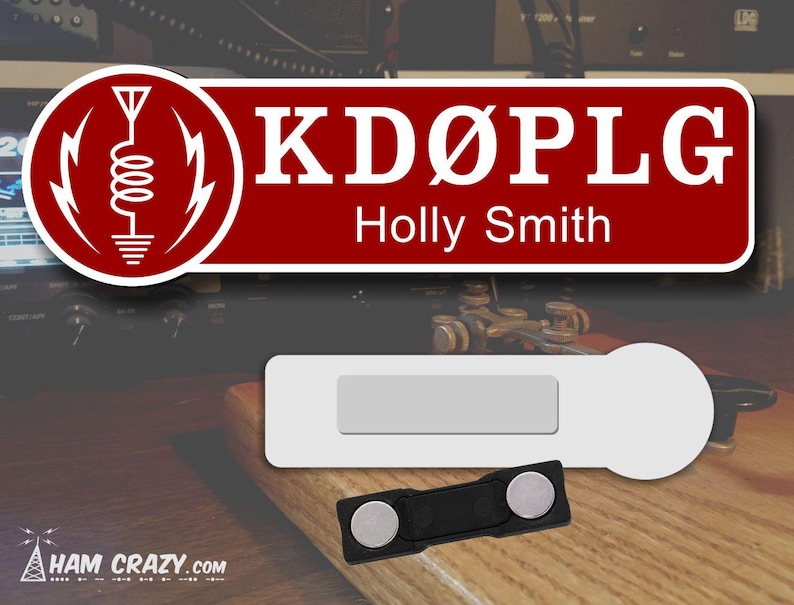 May include: A red and white name tag with the call sign "KD&Oslash;PLG" and the name "Holly Smith" printed on it. The tag is next to a white name tag with a magnetic backing.