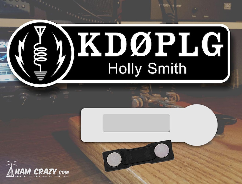 May include: Black and white name tag with the call sign "KD&Oslash;PLG" and the name "Holly Smith" printed on it. The name tag is attached to a white magnetic name tag holder.