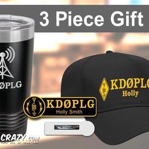 May include: A three-piece gift set for ham radio enthusiasts. The set includes a black stainless steel tumbler with a radio antenna graphic and the call sign "KDØPLG", a black baseball cap with the call sign "KDØPLG" and the name "Holly" embroidered in yellow, and a black and white lapel pin with the call sign "KDØPLG" and the name "Holly Smith".