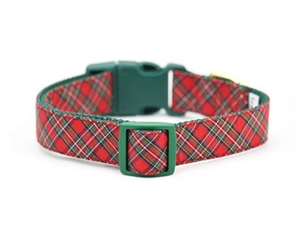 Puede incluir: Un collar para perros de cuadros rojos con detalles verdes. El collar tiene una hebilla de plástico verde y un lazo cuadrado a juego. El patrón de cuadros incluye líneas rojas, blancas, amarillas y verdes.
