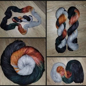 May include: Three skeins of yarn in black, grey, and orange with a gradient of color. The yarn is arranged in a circle, with the black yarn on the outside, the grey yarn in the middle, and the orange yarn on the inside.