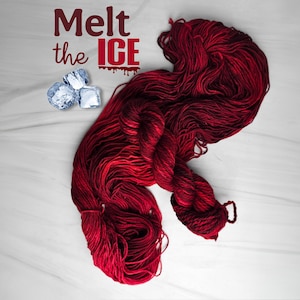 May include: A skein of vibrant red yarn with darker red and black accents, displayed on a white surface. The text "Melt the ICE" is displayed in burgundy. Three ice cubes are in the upper left corner.