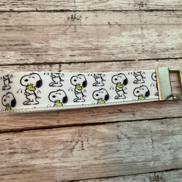 Key fob wristlet made with trademarked Snoopy ribbon.