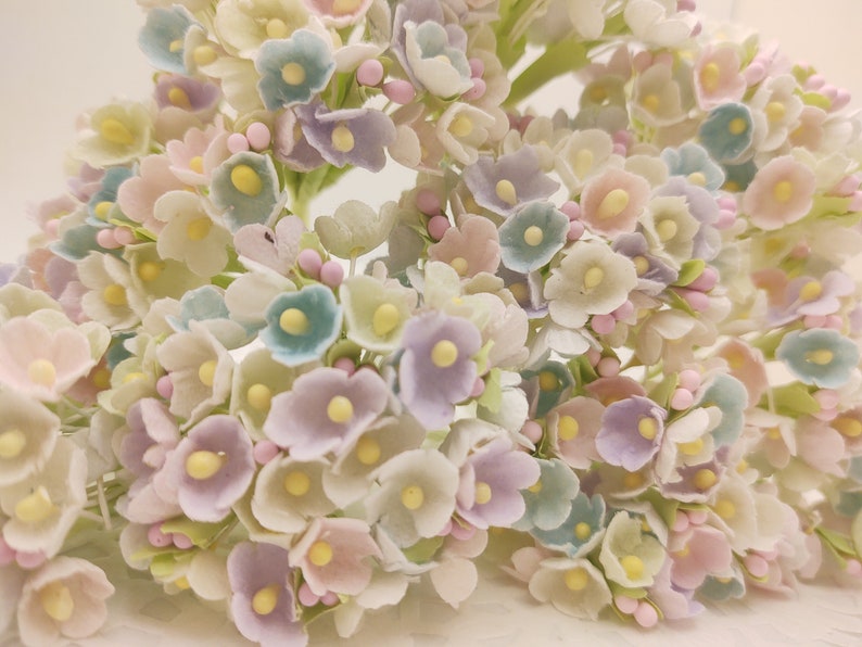 9 mini bouquets of forget me not artificial flowers. Each bouquet has 8 stems and approximately 40 tiny mini flowers total. Colors are pink, lavender, blue and lime/yellow. Flowers are 1/2 inch across and bouquet is 4 inches long. Pastel/Spring mix.