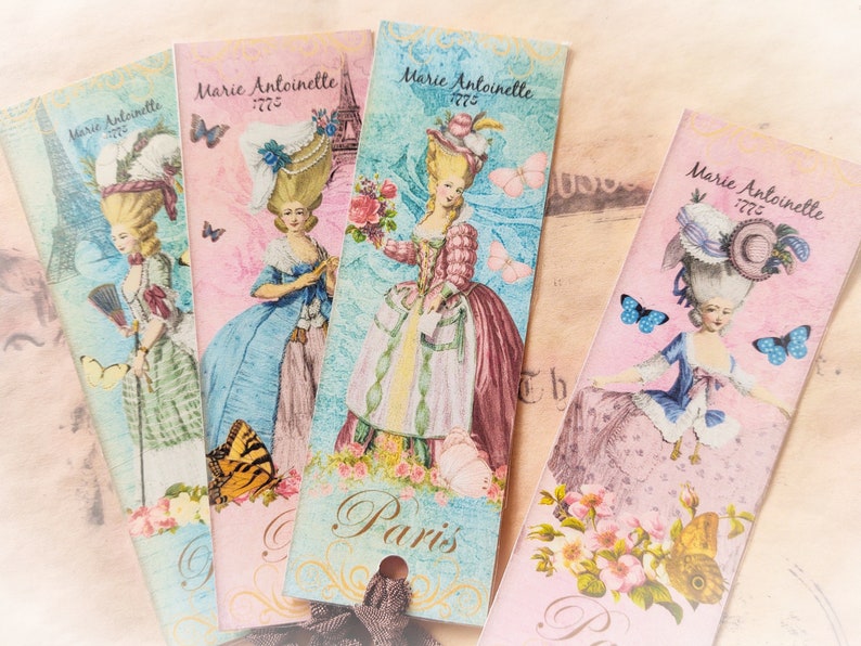 May include: Four pink and blue bookmarks with a vintage design featuring a woman in a dress and a large hat. The bookmarks have the text "Marie Antoinette" and "Paris" on them.