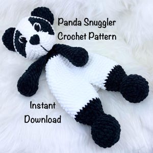 May include: A handmade, black and white panda snuggler crochet pattern. The panda has black ears, arms, and feet, with a white body. The text "Panda Snuggler Crochet Pattern" and "Instant Download" are visible.