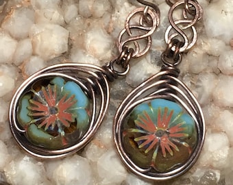 May include: Copper wire wrapped earrings with a turquoise and orange flower design glass bead.