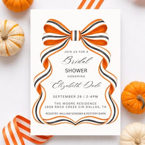 Könnte beinhalten: Eine weiße, rechteckige Einladungskarte für eine Brautparty mit einer großen, orange-schwarz-weiß gestreiften Schleife oben. Der Text lautet: JOIN US FOR A Bridal SHOWER HONORING Elizabeth Dade SEPTEMBER 29 | 2-4PM THE MOORE RESIDENCE 1858 ROCK CREEK CIR DALLAS, TX REGISTRY: WILLIAM SONOMA & POTTERY BARN.