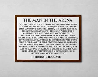 May include: A framed print with a black and white quote by Theodore Roosevelt about the importance of action and perseverance. The quote reads, "It is not the critic who counts; not the man who points out how the strong man stumbles, or where the doer of deeds could have done them better..."