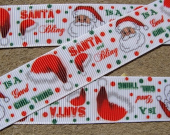 May include: White ribbon with a repeating pattern of Santa Claus, a red hat, and the text "Santa and Bling" and "Is a Good Girl Thing".