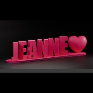 Peut inclure: Une enseigne de nom 3D rose qui lit "JEANNE" avec un cœur rose sur le côté droit.