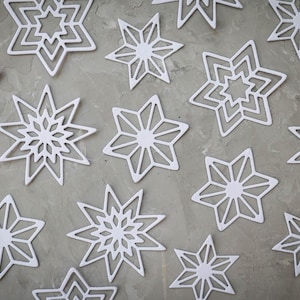 Gestanste kerststerren - benodigdheden voor het maken van witte papieren sterrenkaarten - kinderen knutselen sneeuwvlokversieringen Cadeauverpakking Winter interieur