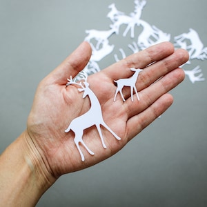 Hertenstansen voor kerstkaarten en feestelijk knutselen - rendieren van wit papier voor het dagelijkse plakboekdecor van december - uitgestanste bosdieren