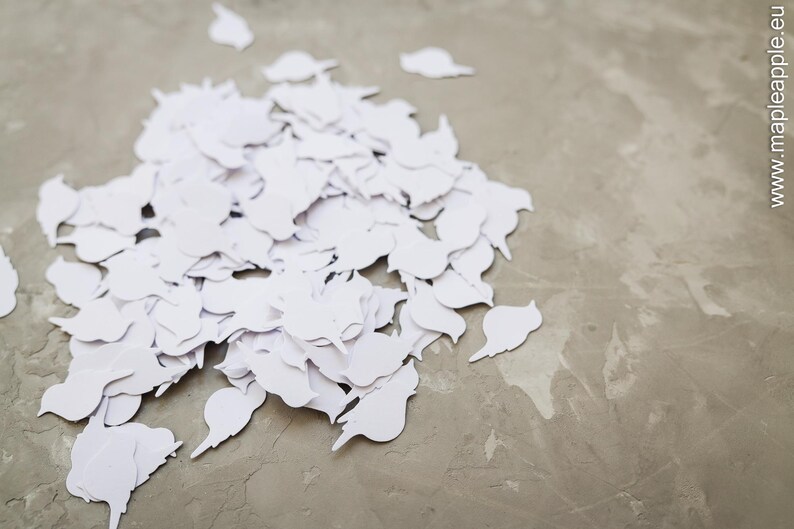 May include: A collection of white bird-shaped paper cutouts scattered on a textured grey surface. Some cutouts overlap. The website address www.mapleapple.eu is visible in the background.