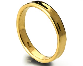 May include: A simple gold wedding band with a smooth, slightly rounded surface. The band is marked with the number "750" on the inside.
