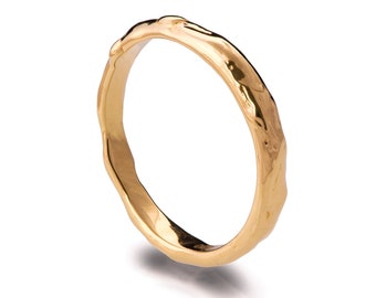 May include: A gold ring with a textured, irregular surface. The ring is smooth and polished on the inside.