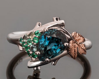 Multi-Stone Ivy Leaf Engagement Ring with a Large Pear Shaped Teal Sapphire and a Cluster of Emeralds and Teal Sapphires