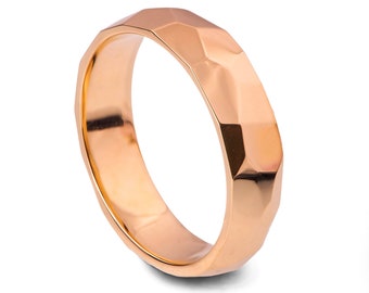 May include: A rose gold wedding band with a faceted, geometric design.
